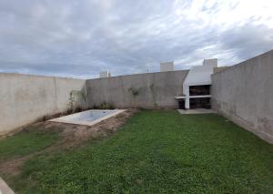 un patio trasero con una pared de hormigón y una piscina en La Casita de Lujan en Luján de Cuyo