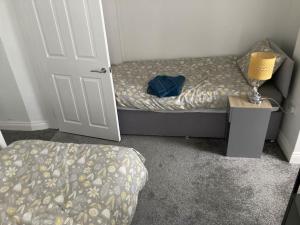 ein Schlafzimmer mit einem Bett und einer Lampe neben einer Tür in der Unterkunft 50 meters from Beach. in Bognor Regis