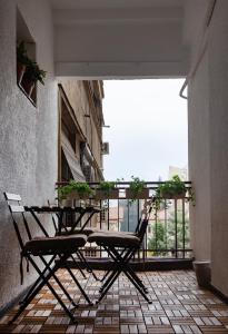 a patio with a table and chairs on a balcony at Ultracentral Hong Kong 3 Bdrm apartment in Bucharest