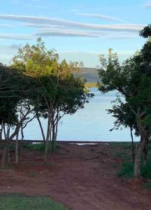 um grupo de árvores em frente a uma massa de água em Casa de temporada no Lago de Furnas-acesso a represa em São José da Barra