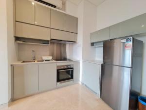 a kitchen with white cabinets and a stainless steel refrigerator at Summer Suite KLCC in Kuala Lumpur