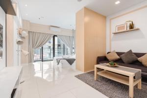 ein Wohnzimmer mit einem Sofa und einem Tisch in der Unterkunft Summer Suite KLCC in Kuala Lumpur