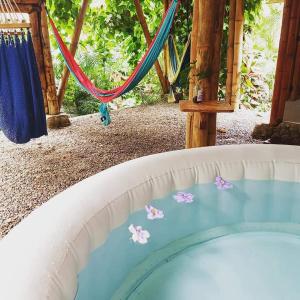 a pool with a swing and flowers in the water at Glamping Due Amici in Palomino