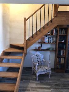a wooden staircase with a chair and a book shelf at Casa la Umbría in Elche de la Sierra
