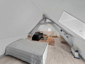 1 dormitorio en el ático con 1 cama y 1 sofá en La Chaumière de MÉDÉE, 
