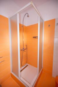 a shower with a glass door in a bathroom at Titika House in Nea Vrasna