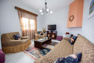 a living room with two couches and a tv at Titika House in Nea Vrasna