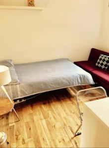 ロンドンにあるCentral London Waterloo - Private Rooms in Shared Apartmentの赤いソファ付きの部屋のベッド1台