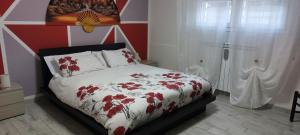 een slaapkamer met een bed met een rode en witte deken bij Appartamento Giotto in Cento