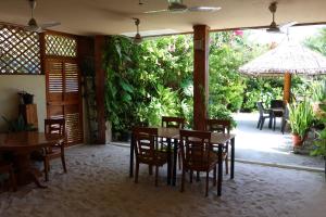 a dining room with tables and chairs and a patio at Hanifaru Transit Inn in Dharavandhoo