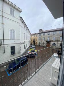 einen Balkon mit Blick auf eine Straße mit Autos in der Unterkunft La casa nel vicolo Camera 2 in Casale Monferrato
