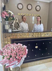 duas mulheres em frente a um espelho com um ramo de flores em Diamond Hotel em Chisinau