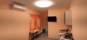 a room with a room with a table and a television at Termálvölgy Vendégház in Gelse