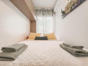 1 dormitorio con 1 cama grande y toallas. en Amazing 2 bedroom Apartment with big sun terrace Sitges centre beach en Sitges