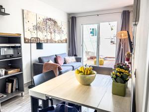 una sala de estar con una mesa con un tazón de plátanos. en Amazing 2 bedroom Apartment with big sun terrace Sitges centre beach en Sitges
