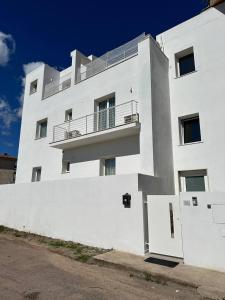 奧爾比亞的住宿－Blessed House Rooms，一座白色的建筑,上面设有一个阳台