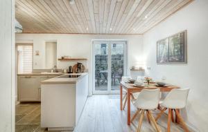 a kitchen with a wooden ceiling and a table and chairs at Waldblick in Glücksburg