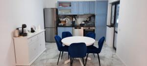 a kitchen with blue cabinets and a white table and chairs at Casa Bellevue in Bacău