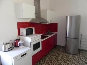 uma cozinha com um frigorífico e um micro-ondas em Apartamento en Masia catalogada em Tarragona