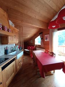 una cocina con una mesa roja en una cabaña en DUPLEX 50 m2 aux pieds des pistes les saisies hauteluce et contamines montjoie savoie 6 à 8 personnes 1 chambre et un coin nuit, en Hauteluce