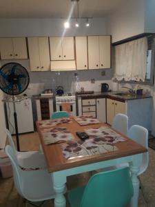 una cucina con tavolo in legno e sedie bianche di FRIDA APARTMENT remis gratis a Ezeiza a Ezeiza