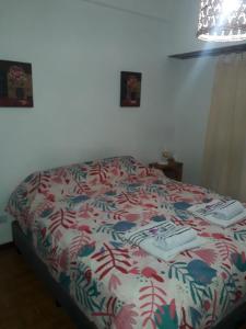 una camera da letto con un letto con un piumone colorato di FRIDA APARTMENT remis gratis a Ezeiza a Ezeiza