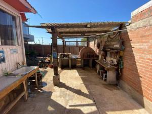 an outdoor kitchen with a wooden pergola at Amplia Casa a 4 cuadras de playa in Los Vilos