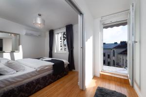 um quarto com uma cama e uma grande janela em Two-level apart with a terrace near the Vltava River em Praga