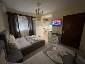 Cette chambre comprend deux lits et une télévision. dans l'établissement Sota Apartment, à Berat