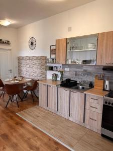 una cucina con armadi in legno, un tavolo e una sala da pranzo di Apartments Roko a Pridraga