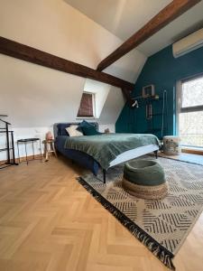 1 dormitorio con paredes azules, 1 cama y 1 alfombra en Charmant Appartement proche Strasbourg à Eckwersheim, en Eckwersheim