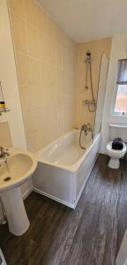 uma casa de banho com uma banheira, um lavatório e um WC. em Tranquil Lodge hot tub and free golf em Swarland