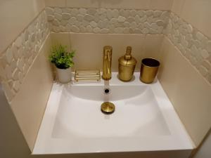 un lavabo de baño con artículos de oro. en La porte dorée..., en Saint-Nicolas-de-la-Grave