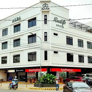 een wit gebouw met een bord aan de zijkant bij Rudolfo Suites in Roxas City
