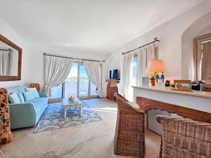 uma sala de estar com um sofá azul e uma mesa em Residence Balocco Porto Cervo em Porto Cervo