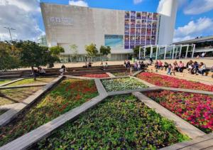 a park with flowers in front of a building at Super Spacious 2BD Habima TLV heart, Balcony & Parking in Tel Aviv
