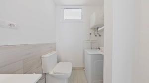 een witte badkamer met een toilet en een wastafel bij Mirador 23 Sea View By Pride Holiday Rentals in San Agustin