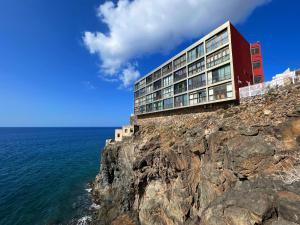 un edificio en un acantilado junto al océano en Mirador 23 Sea View By Pride Holiday Rentals en San Agustín