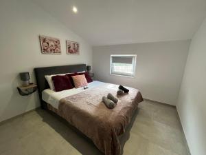 - une chambre avec un lit avec deux animaux rembourrés dans l'établissement Apartment Katarina - peaceful and modern place in the nature, à Krk