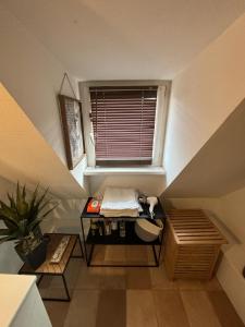 een zolderkamer met een tafel en een raam bij Charmant Appartement proche Strasbourg à Eckwersheim in Eckwersheim