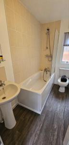 uma casa de banho com uma banheira, um lavatório e um WC. em Jax Retreat hot tub and free golf em Felton