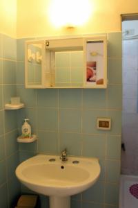 ein Bad mit einem Waschbecken und einem Spiegel in der Unterkunft Don Vito's Apartments in Castellammare del Golfo