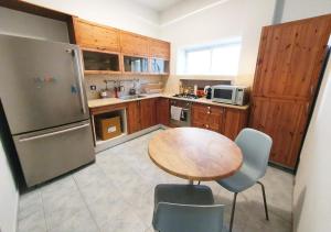 a kitchen with a table and a stainless steel refrigerator at Super Spacious 2BD Habima TLV heart, Balcony & Parking in Tel Aviv