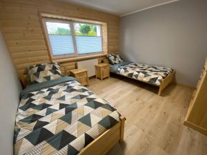 um quarto com 2 camas e uma janela em Apartament Góral em Krynica-Zdrój