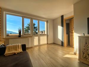 uma sala de estar com um sofá e janelas grandes em Apartament Góral em Krynica-Zdrój