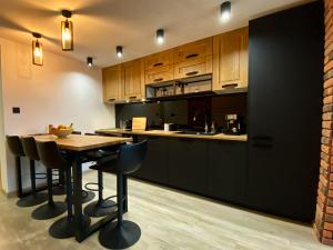 uma cozinha com armários de madeira e uma mesa e cadeiras em Apartament Góral em Krynica-Zdrój