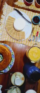 una mesa de madera con platos y utensilios. en Recanto Duas Rosas, en Venda Nova do Imigrante