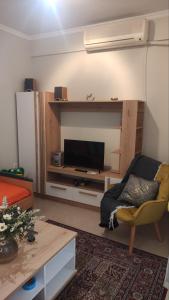 a living room with a tv and a couch and a table at Quiet spacious apartment in Nafplio in Nafplio