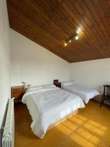 カルデス・デ・マラベーリャにあるMas Gelabertóの木製の天井が特徴のベッドルーム1室(ベッド2台付)