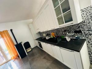 een keuken met witte kasten en een zwart aanrecht bij B&B Love - HOLIDAY HOUSE- Casa Vacanza Santa Severa in Santa Severa
